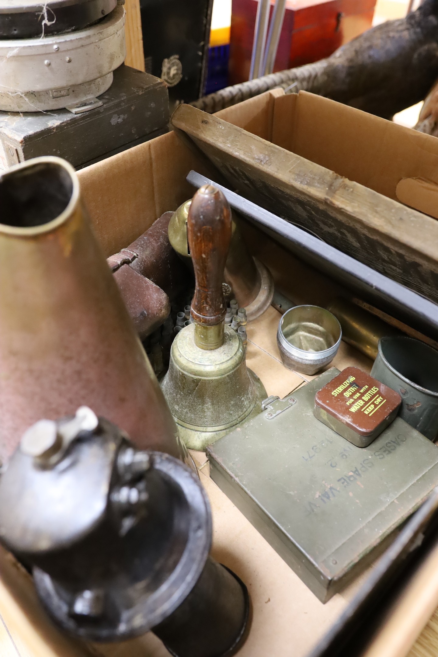 World War Two accessories to include an ARP hand-bell, three compasses and a brass loud-haler